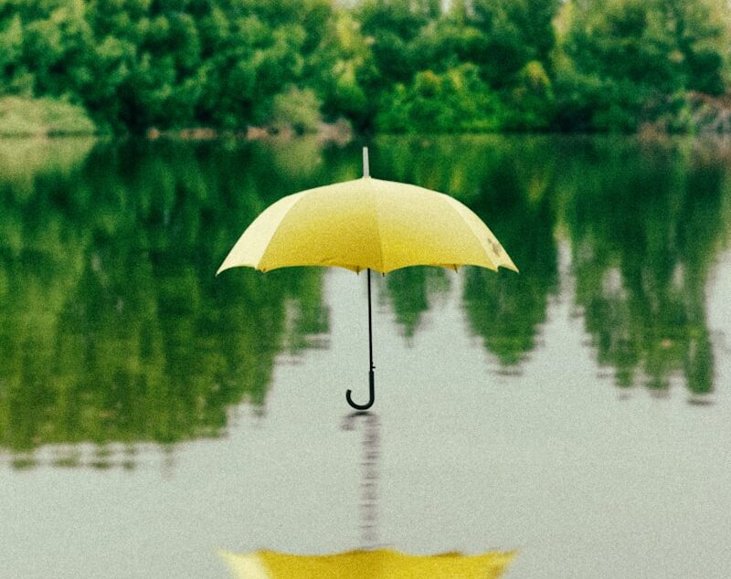 yellow umbrella on surface of water at daytime